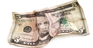 Crumpled five dollar bill